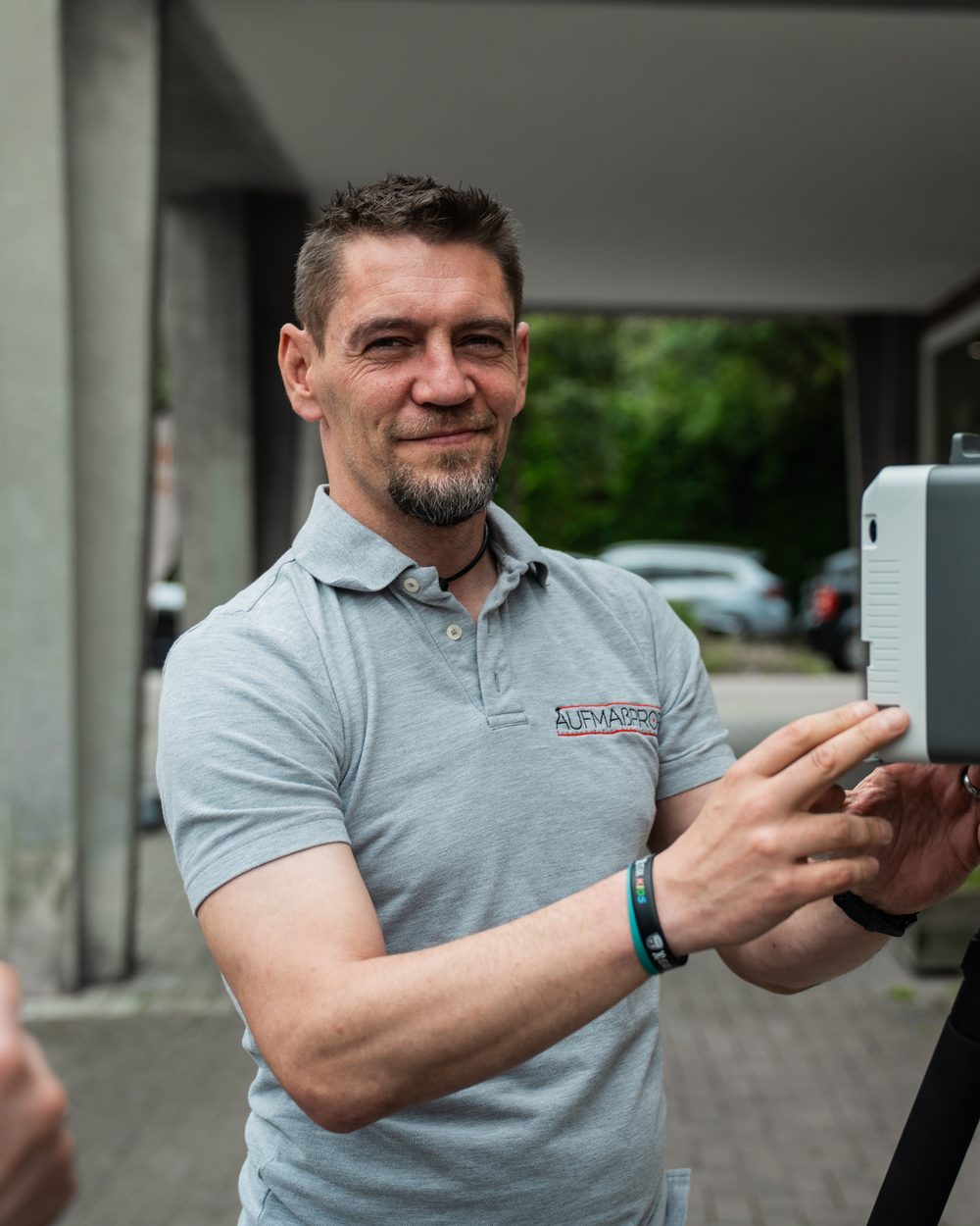 Aufmaßtechniker von Aufmaßprofi mit 3D-Laserscanner auf dem Stativ